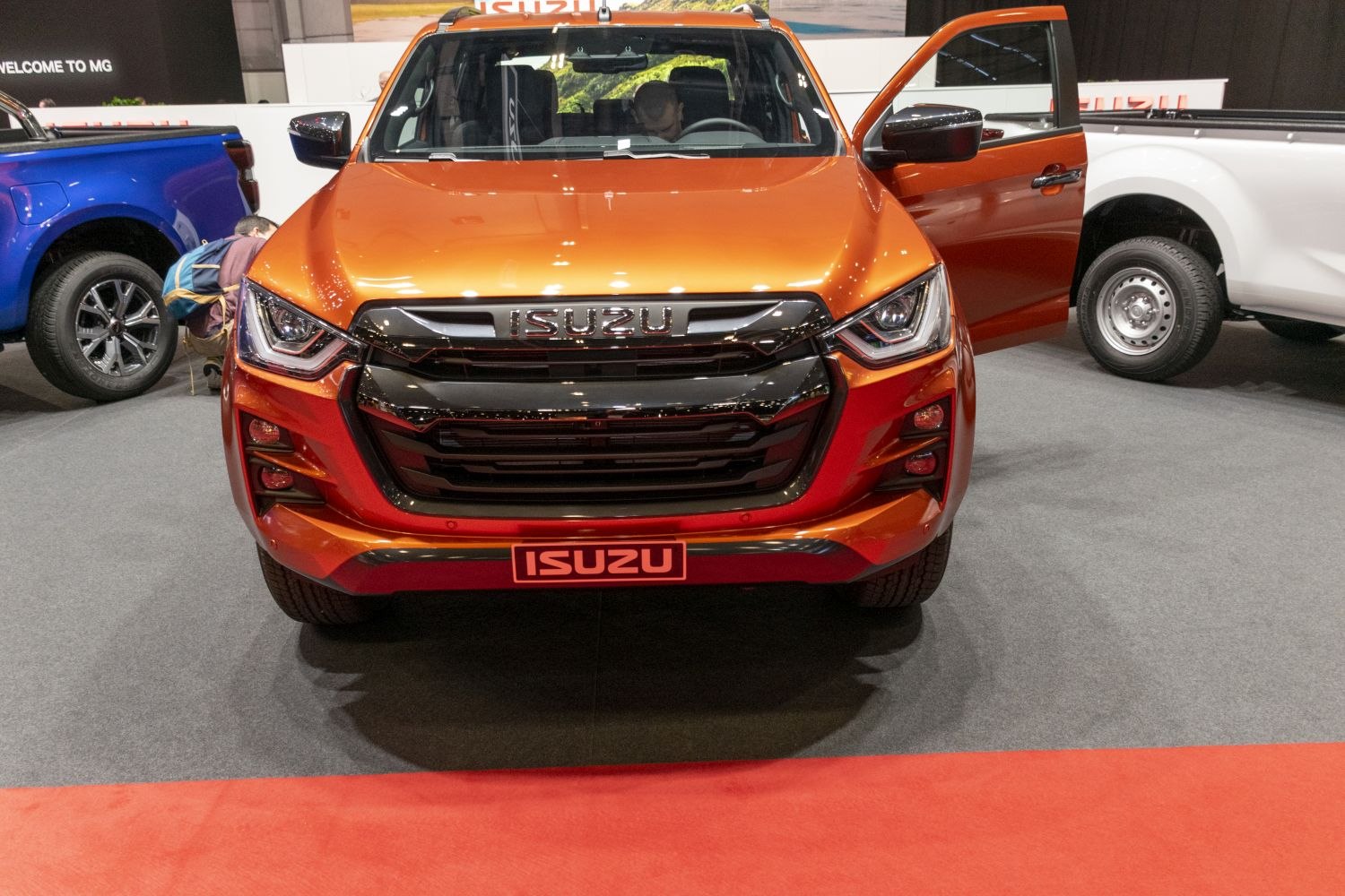 Front view with aggressive grille and LED headlights of orange pickup
