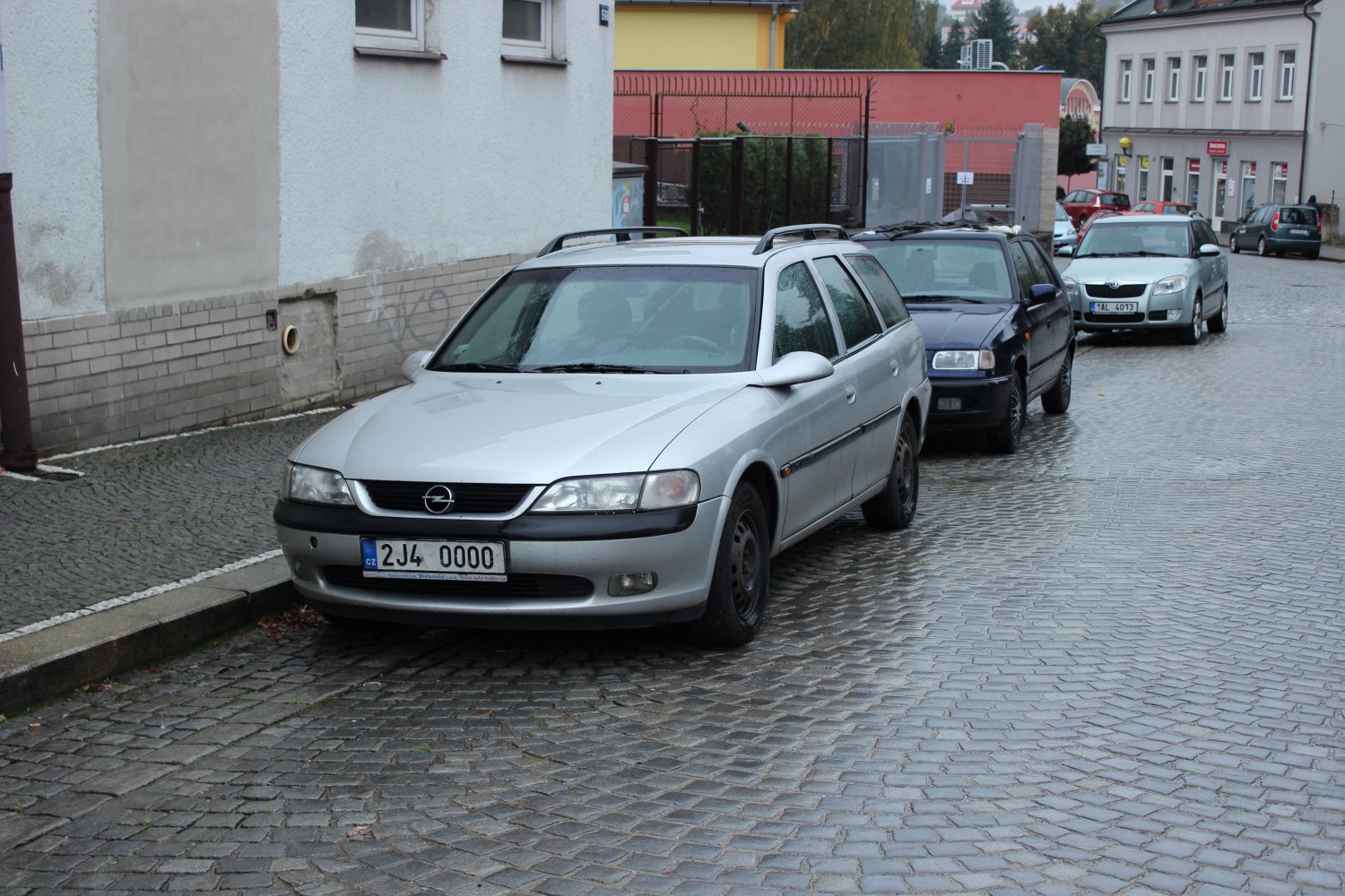 Front view of silver station wagon with roof rails on cobblestone street