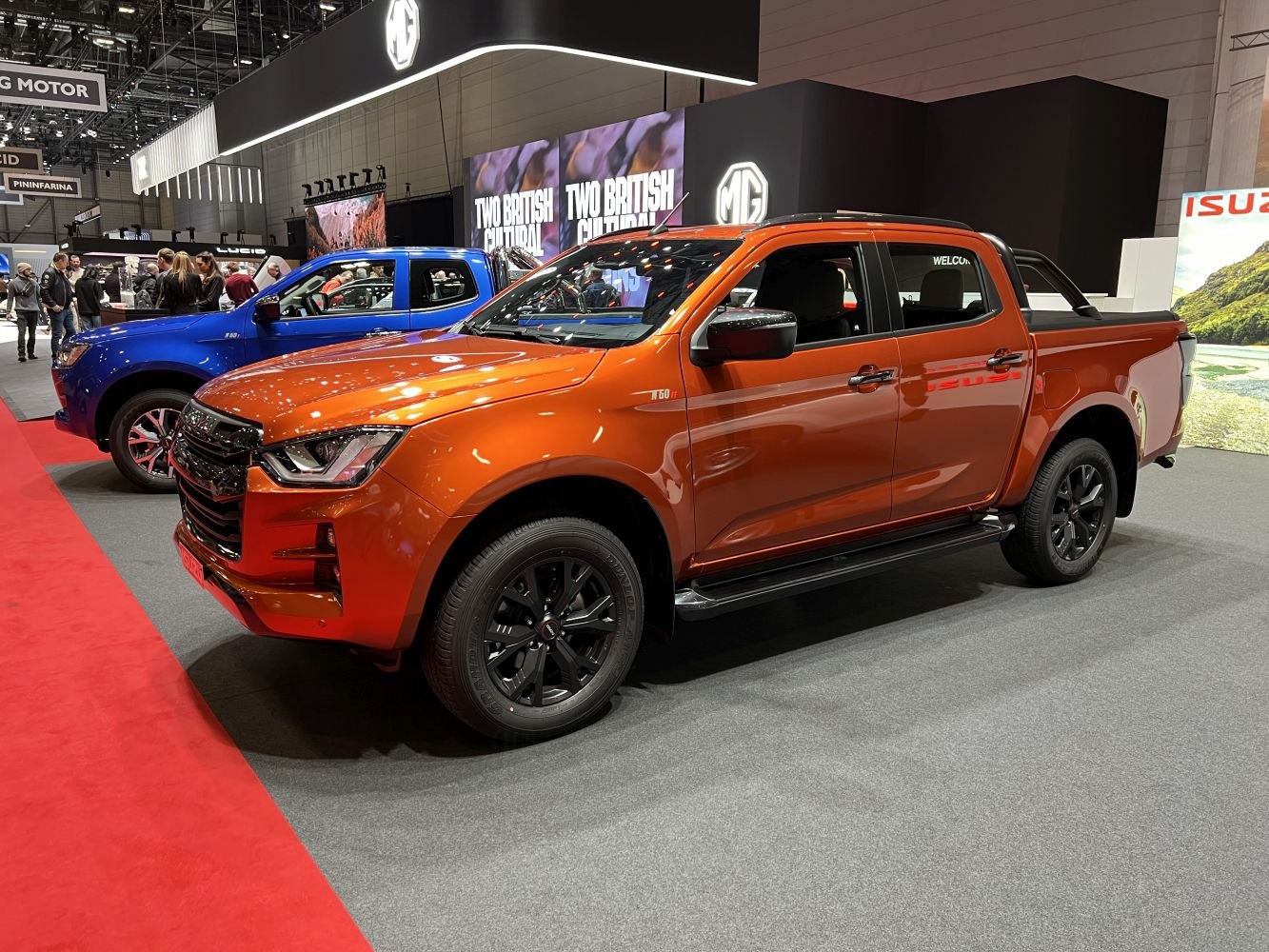 Orange double cab pickup with black wheels on display