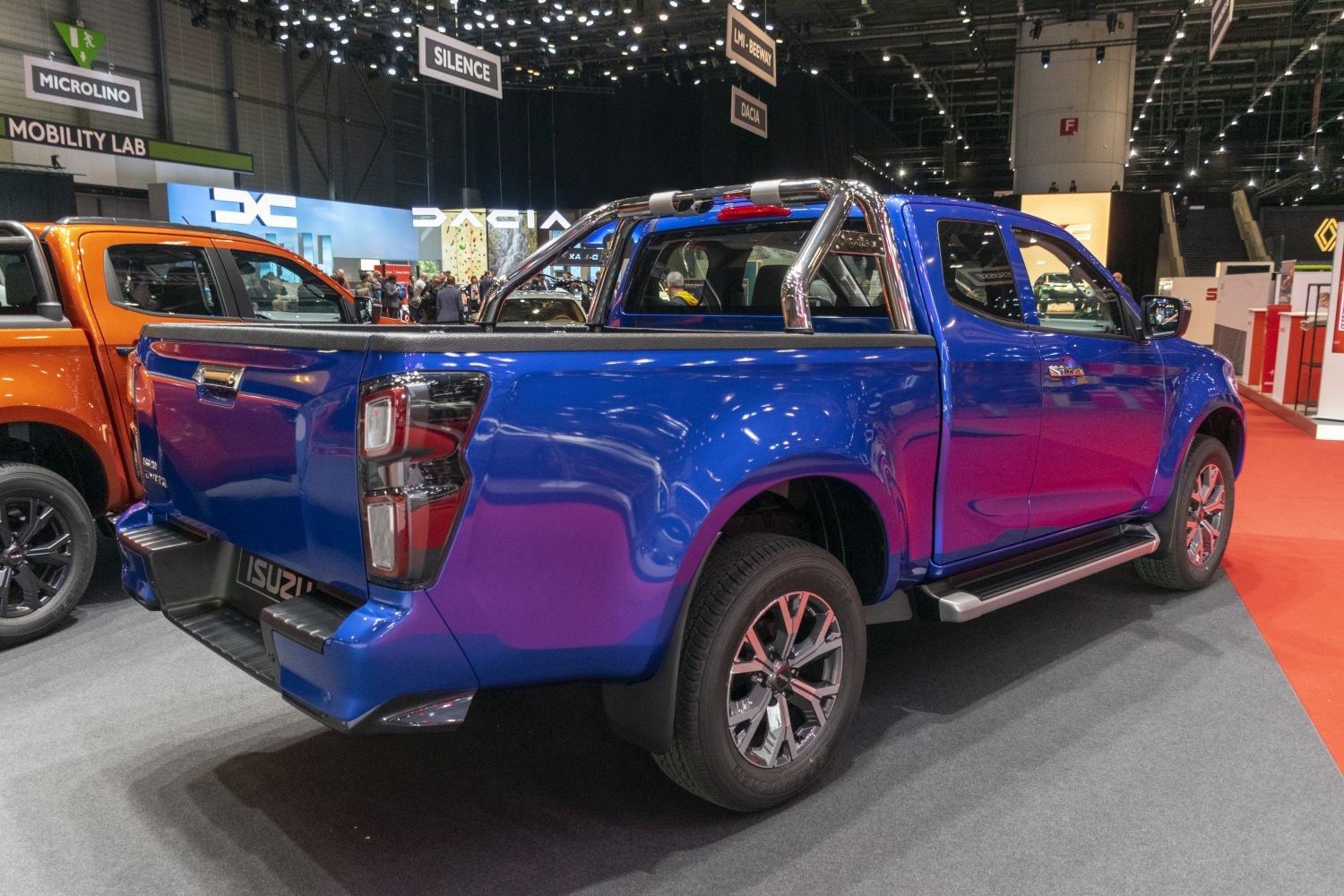 Rear side view of blue pickup with chrome roll bar and alloy wheels