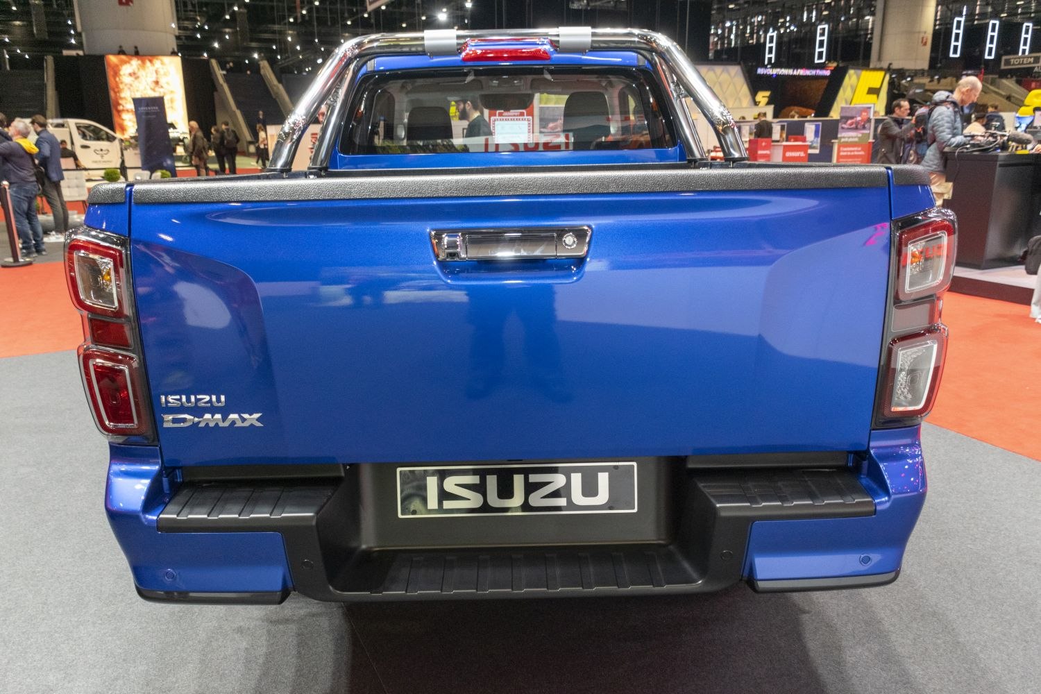 Tailgate and rear bumper design with integrated lights on a blue pickup.