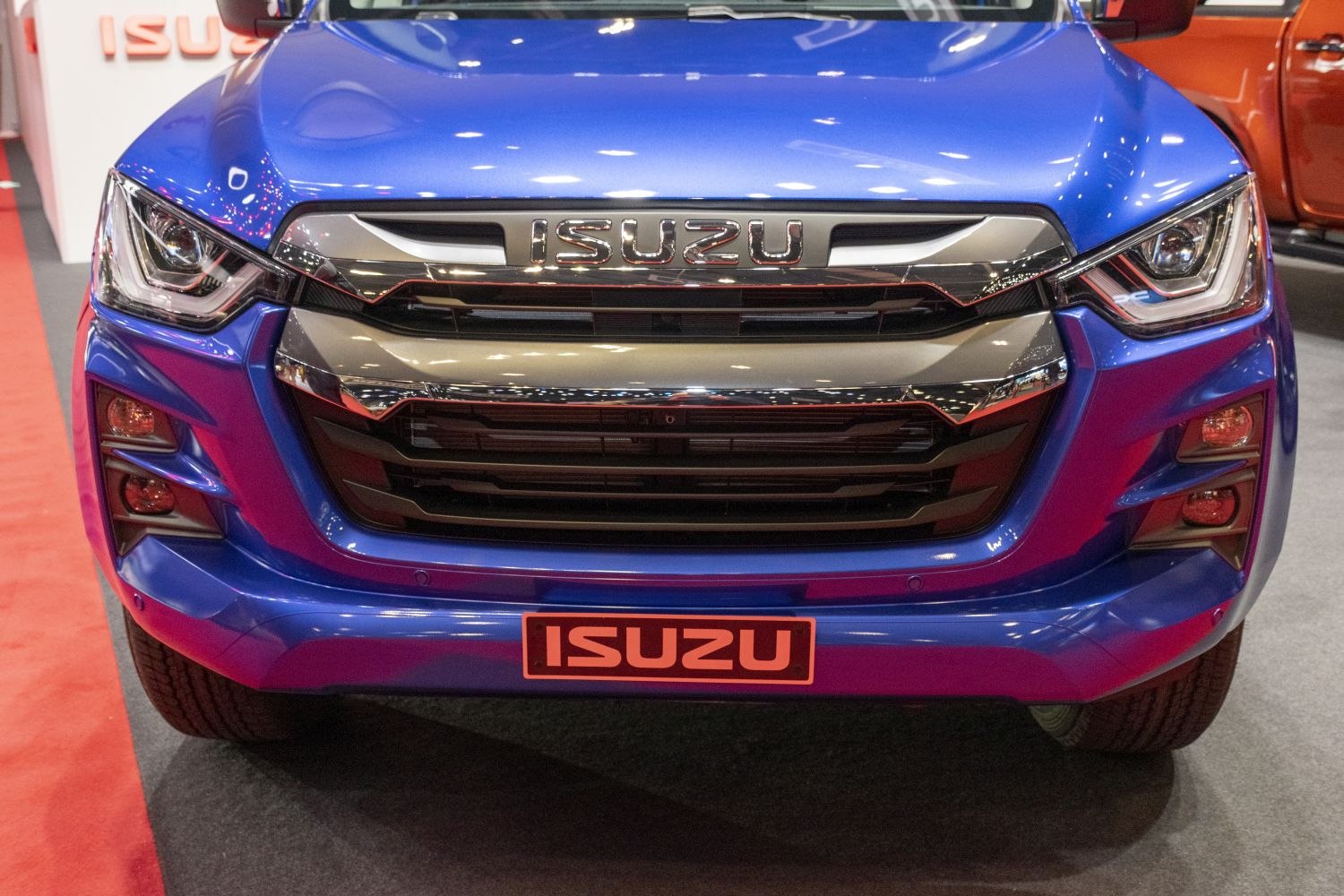 Front grille and angular LED headlights of a blue pickup truck
