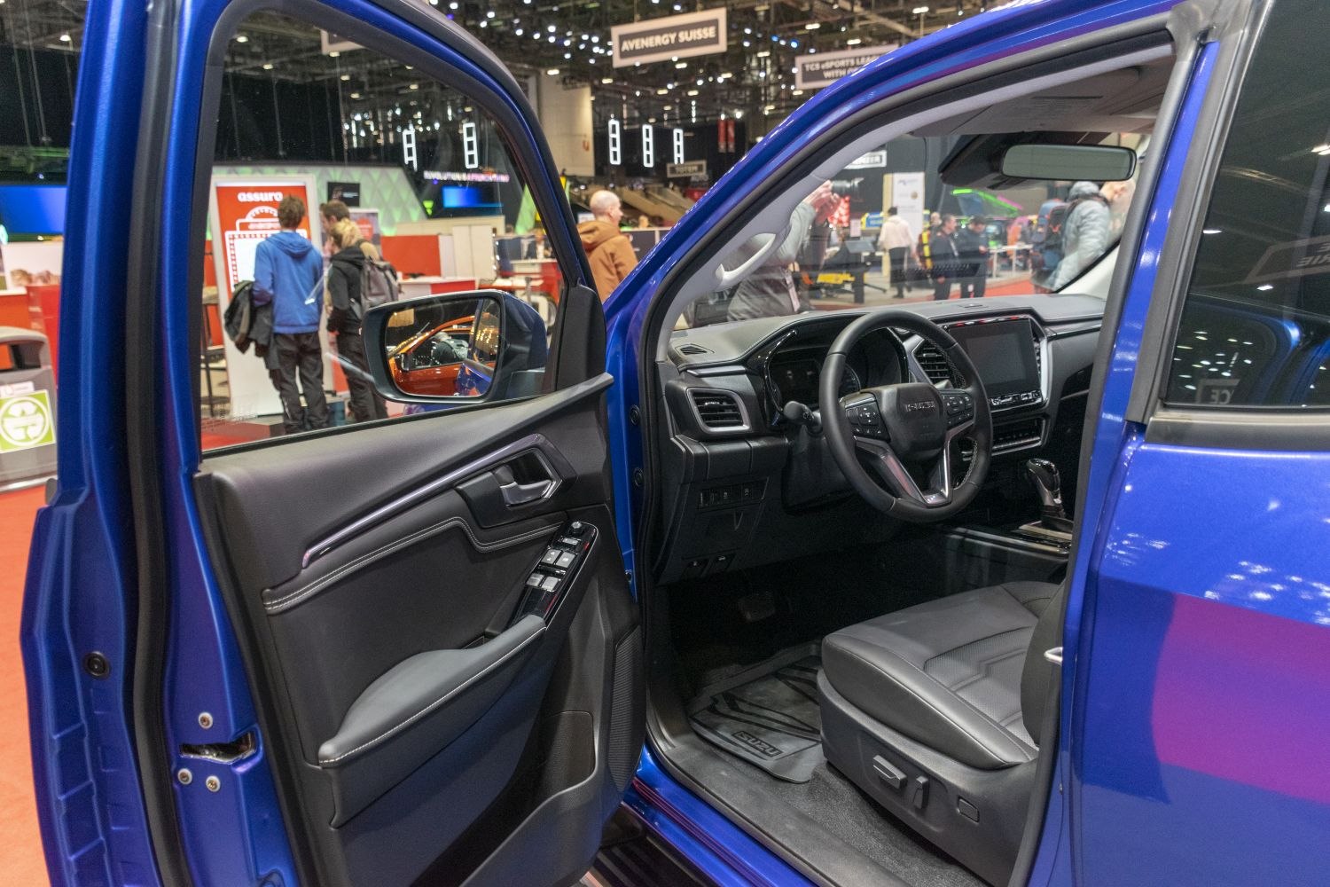 Open vehicle door revealing driver seat, steering wheel, and dashboard