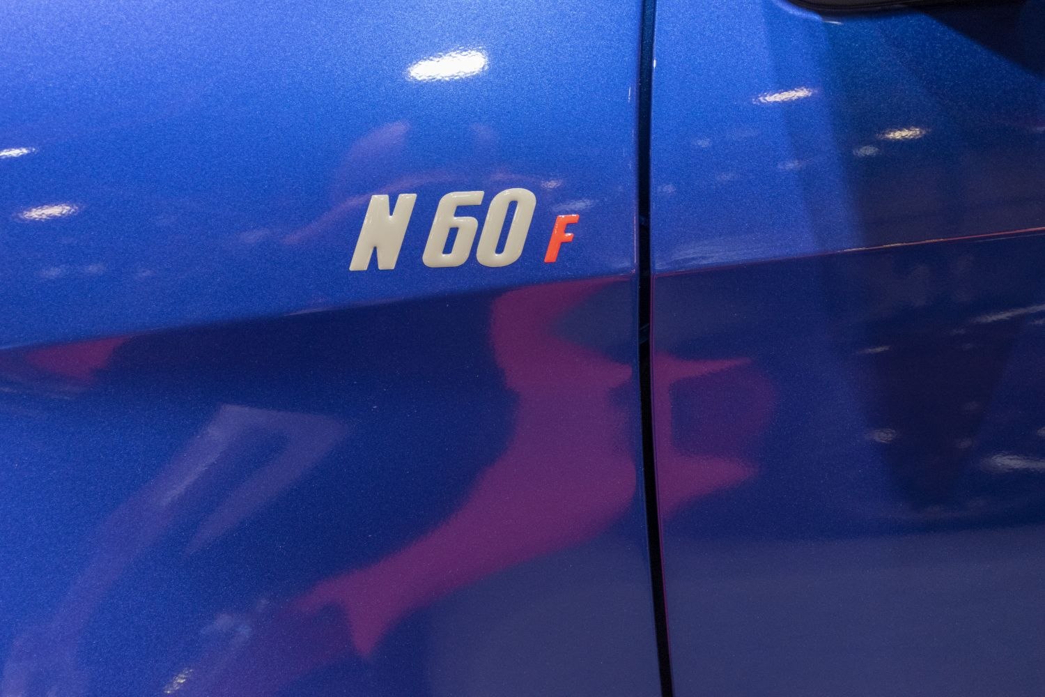Close-up of N60F badge on blue vehicle side panel