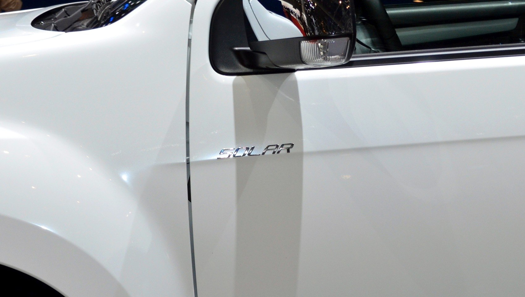 Close-up of solar trim badge and side mirror on white pickup truck