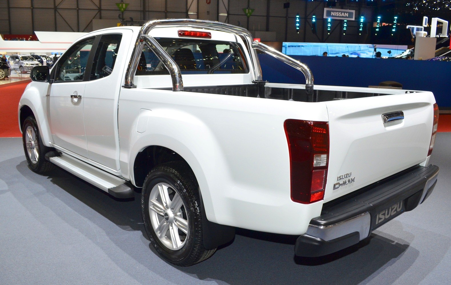 Rear-side view of a white pickup with chrome sports bar and alloy wheels.