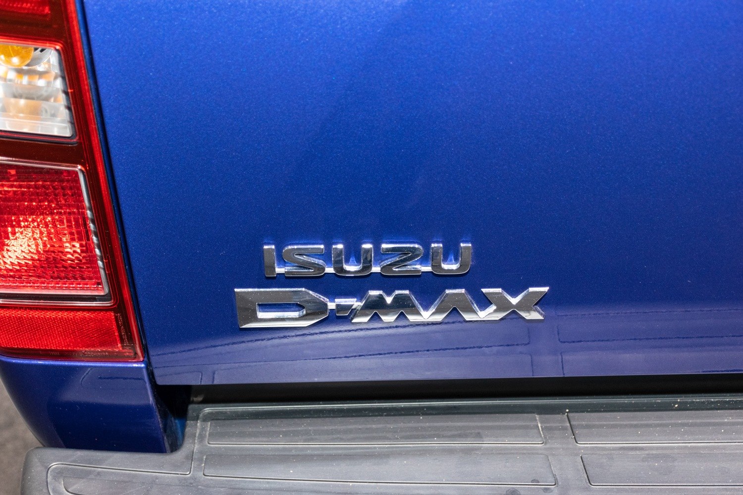 Close-up of rear badge and tail light of blue pickup truck