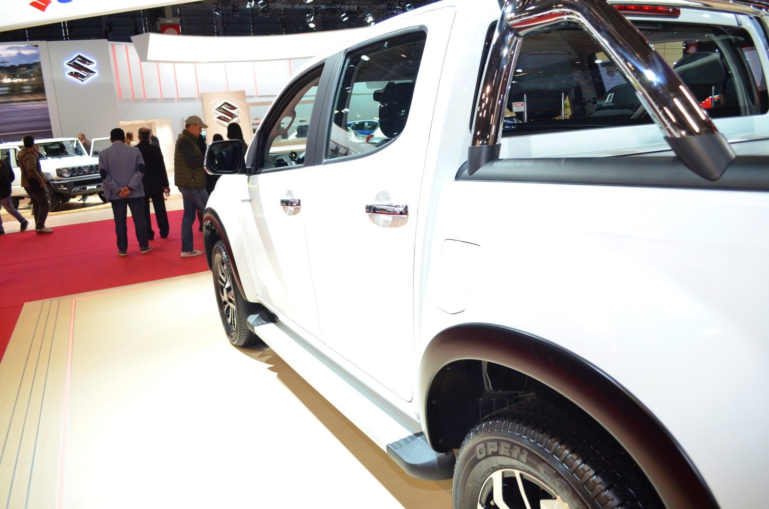 Side view of white pickup with chrome roll bar and alloy wheels