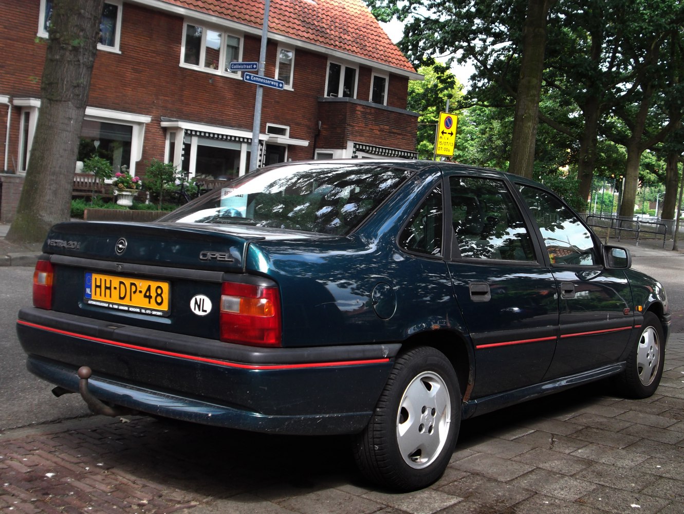 Rear-side view of a 1990s four-door sedan with classic 90s design.