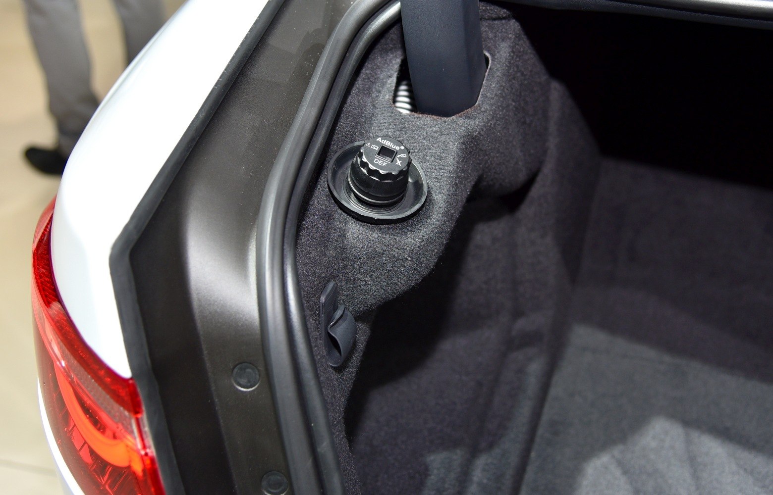 Close-up of AdBlue DEF fluid cap inside a trunk compartment