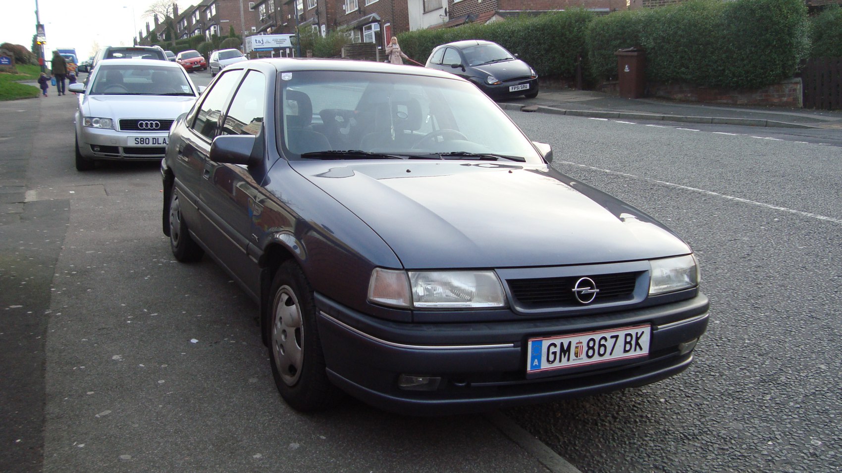 Dark sedan front with rectangular headlights and black grille