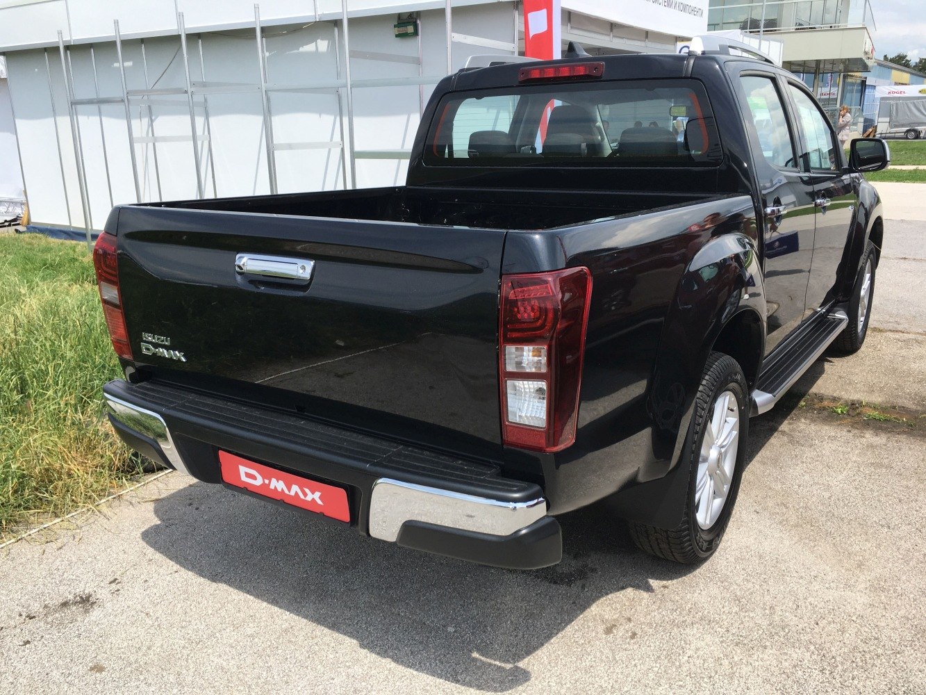Rear and cargo bed view of a black pickup truck with tail lights and bumper.