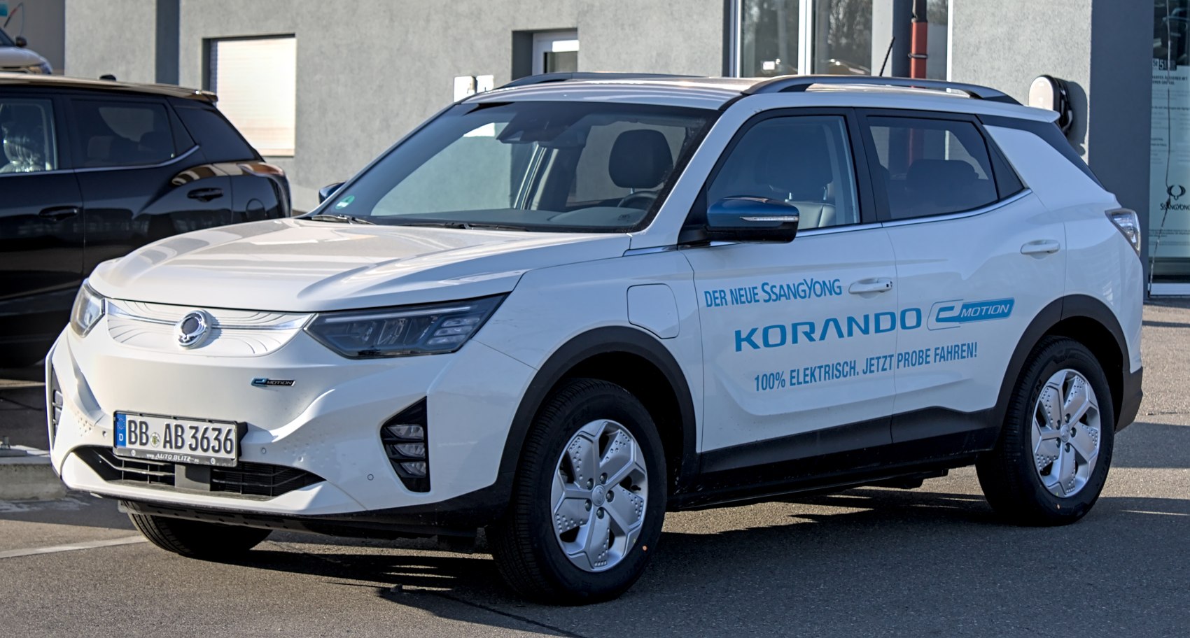Front side view of white electric SUV with aerodynamic design and charging port