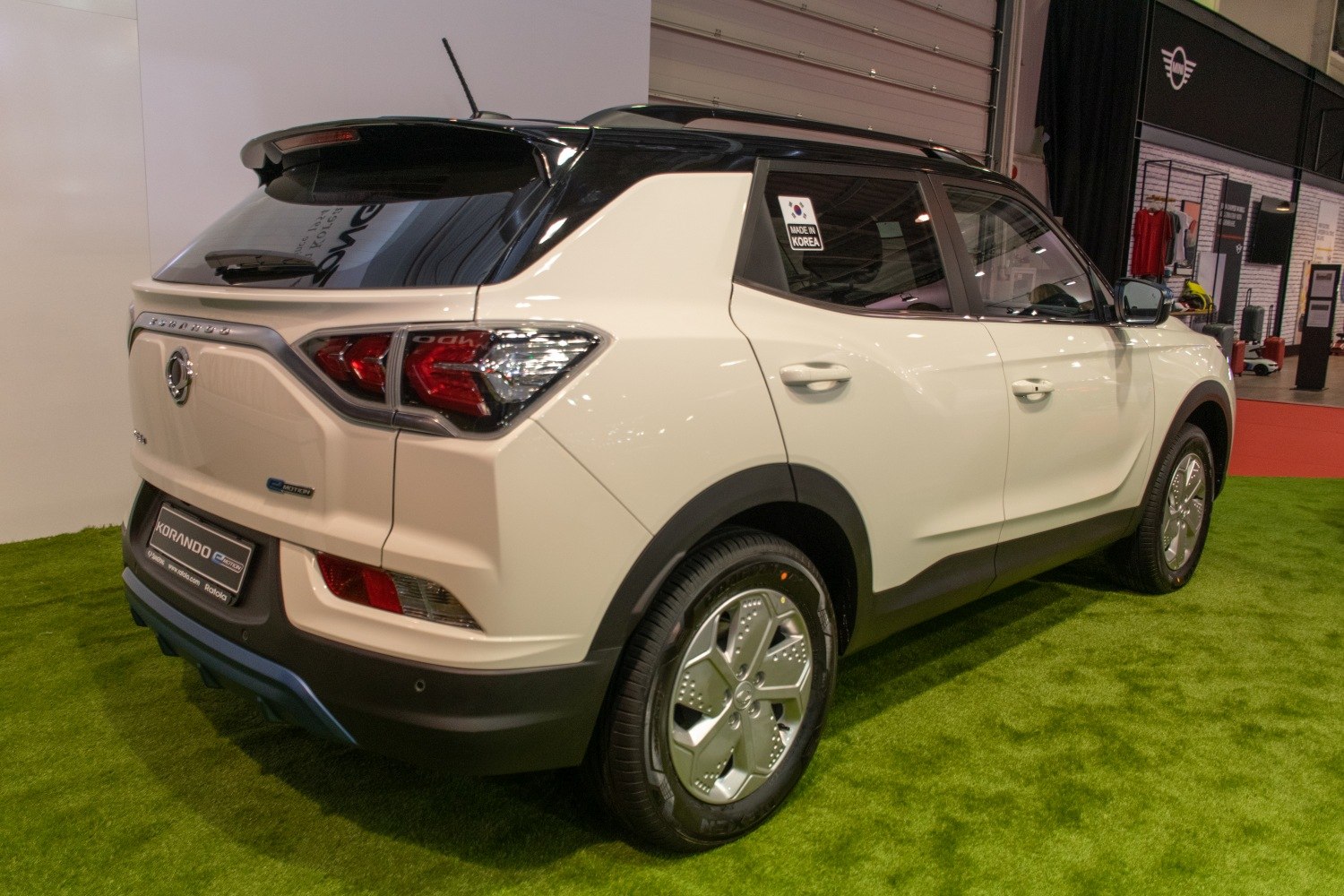 Rear and side view showing tail lamps, alloy wheels, and two-tone paint details