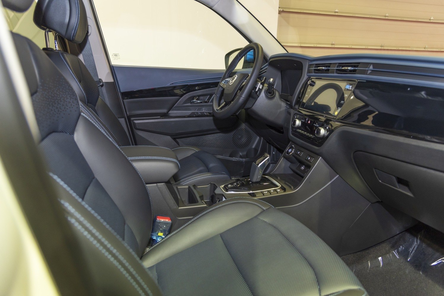 Black leather front seats with detailed stitching and sleek dashboard with touchscreen.