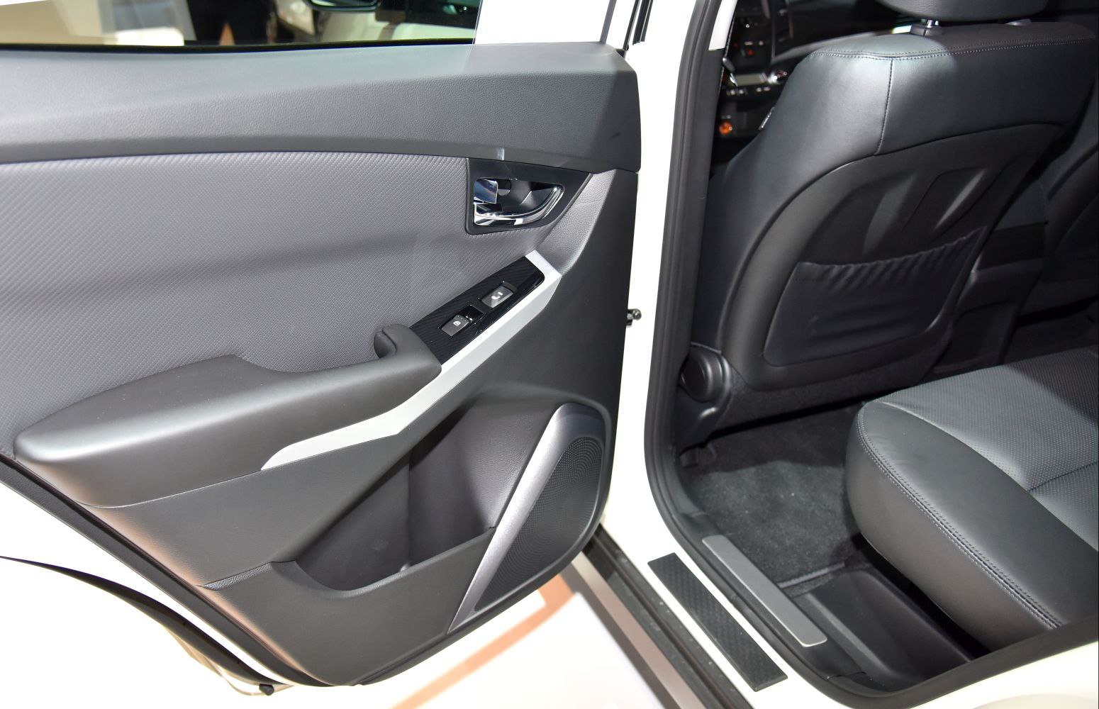 Rear door panel with window controls and partial rear seat interior