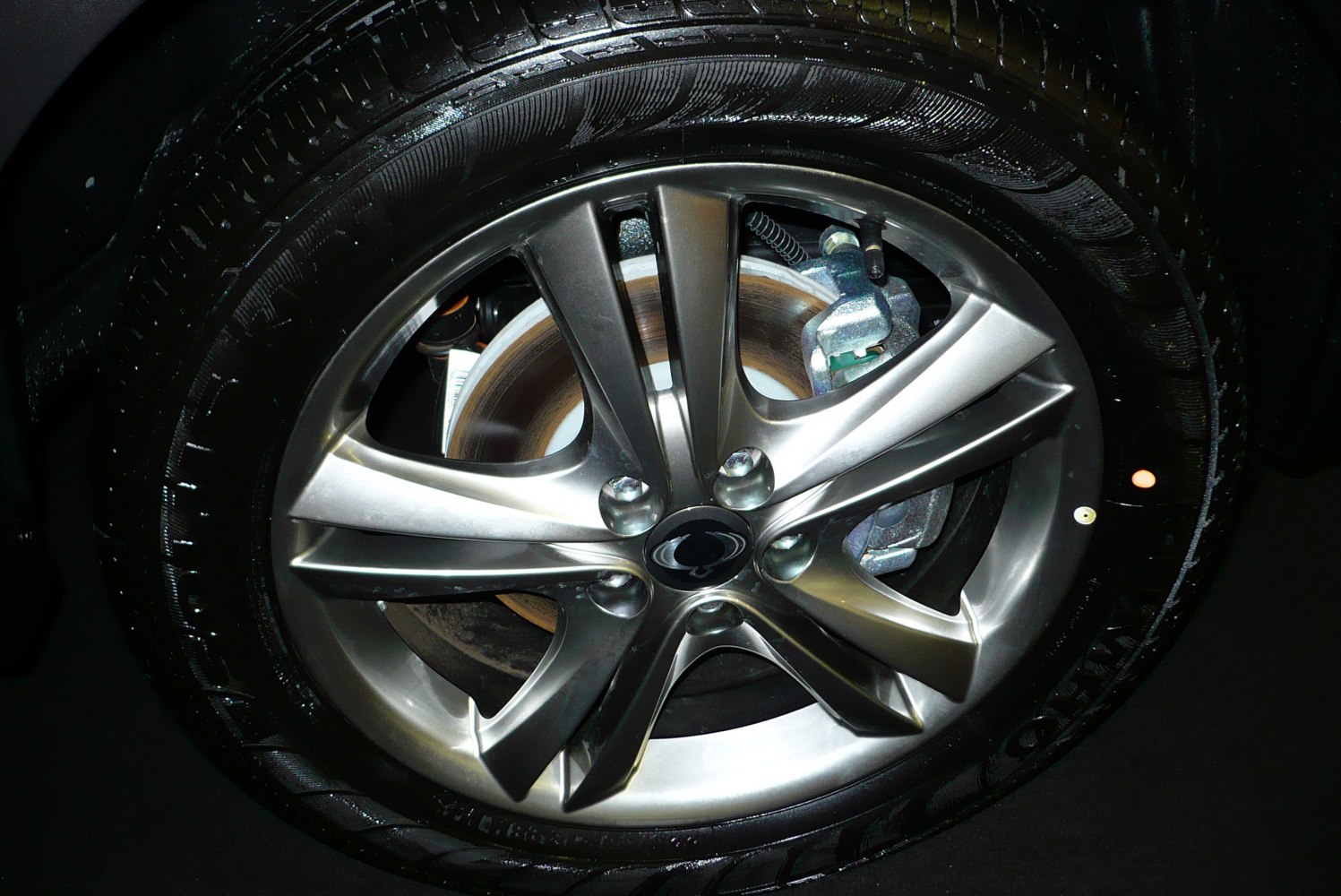 Close-up of metallic alloy wheel with disc brake and brake caliper