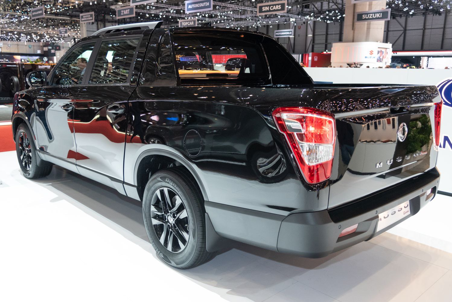 Rear and side profile of a black pickup truck with alloy wheels and distinctive tail lights