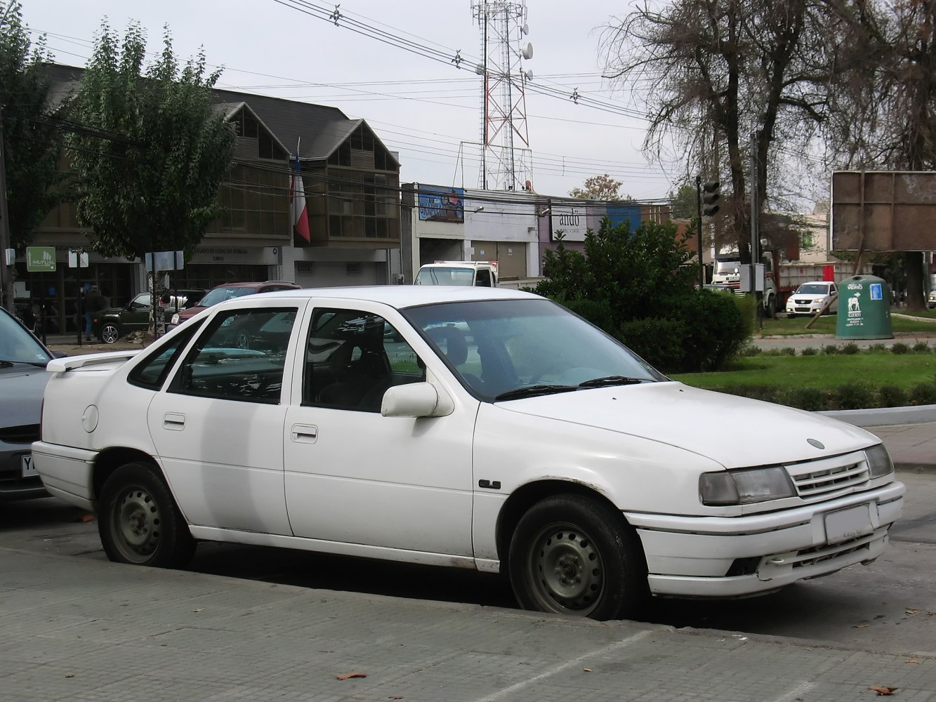 White 4-door sedan with rear spoiler and steel wheels
