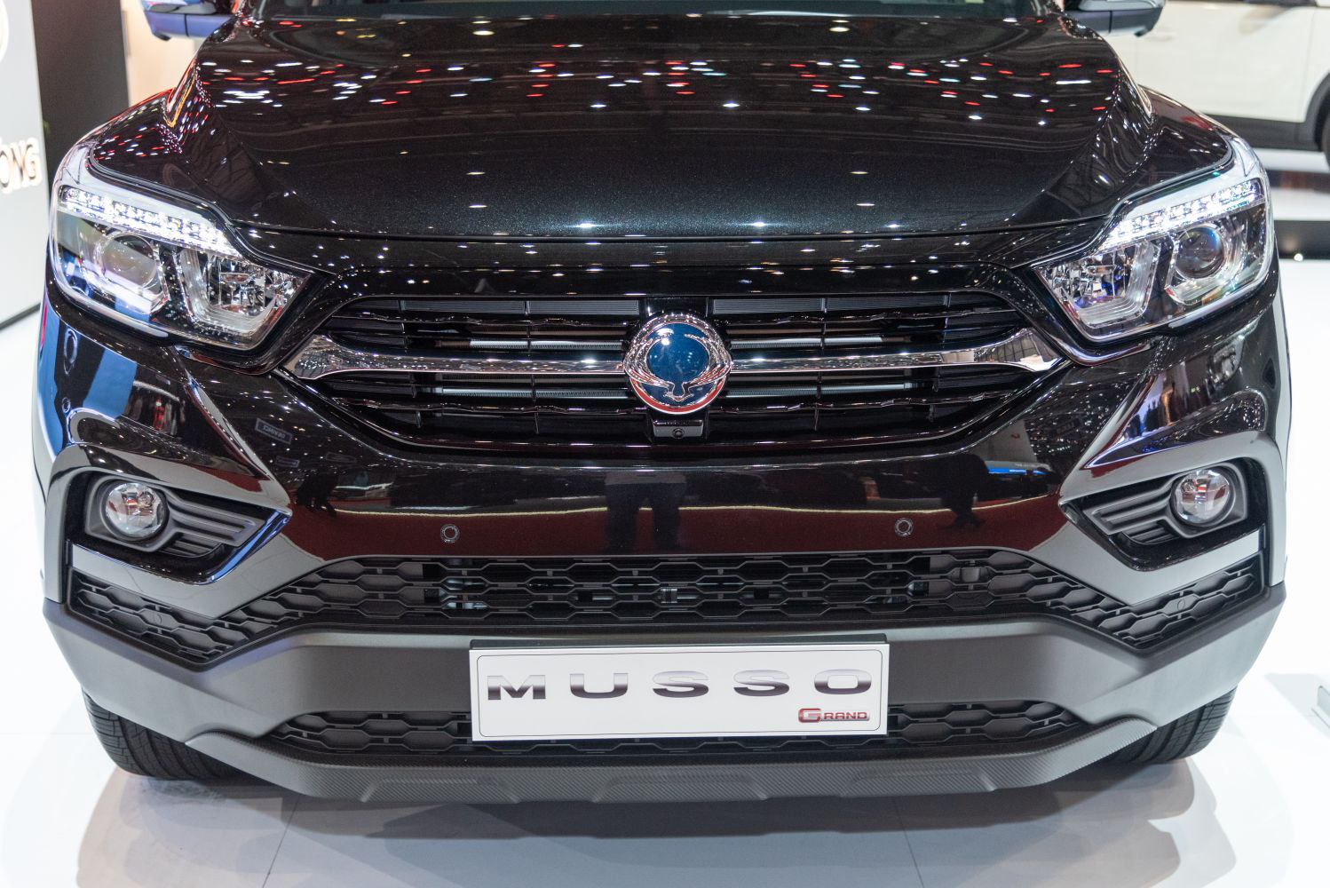 Front grille with badge, LED headlights, and fog lights of a pickup truck