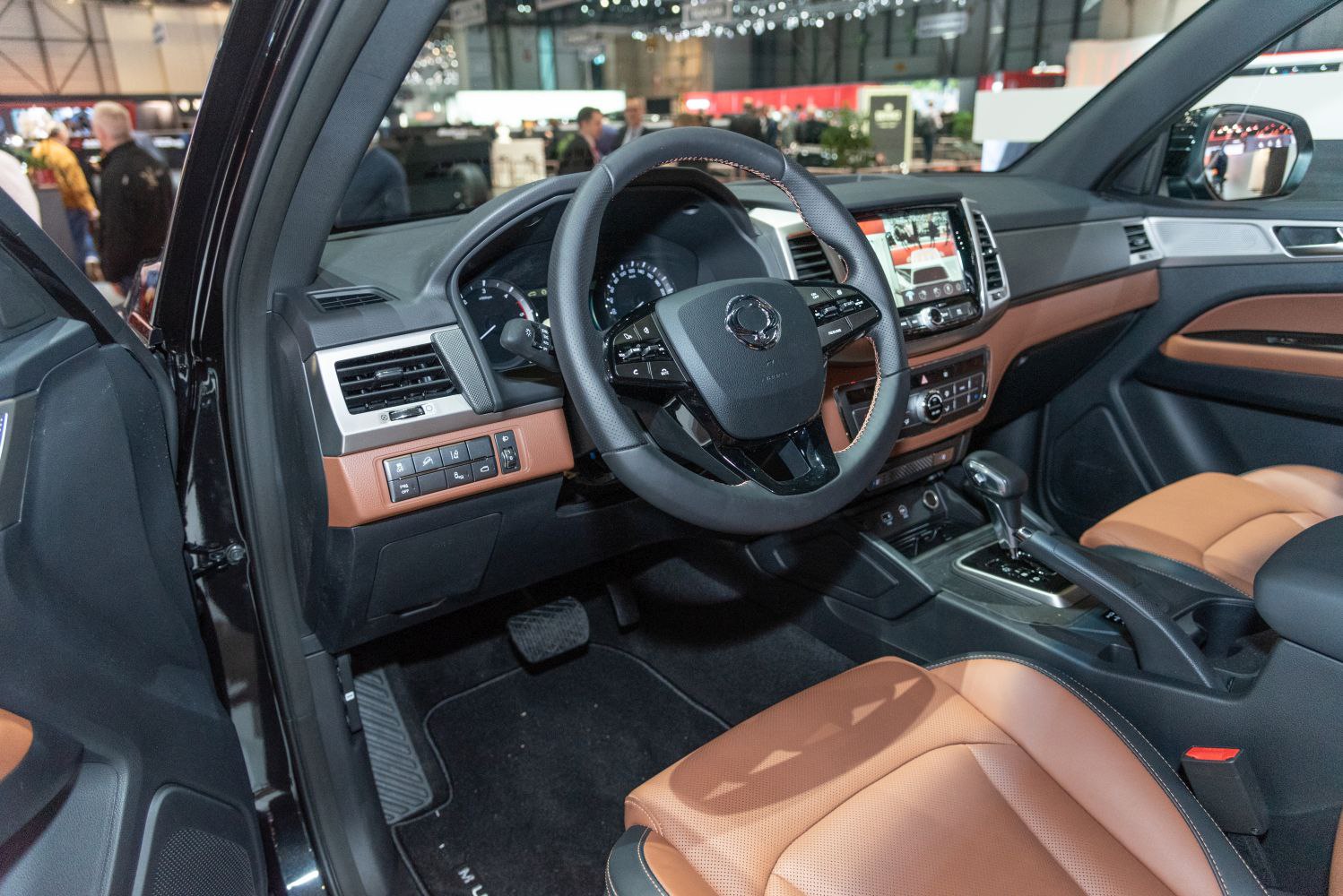 Car interior with dashboard, steering wheel, and leather seats