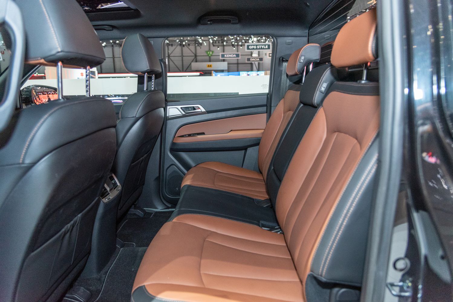Two-tone brown and black leather rear seats with headrests in spacious car interior