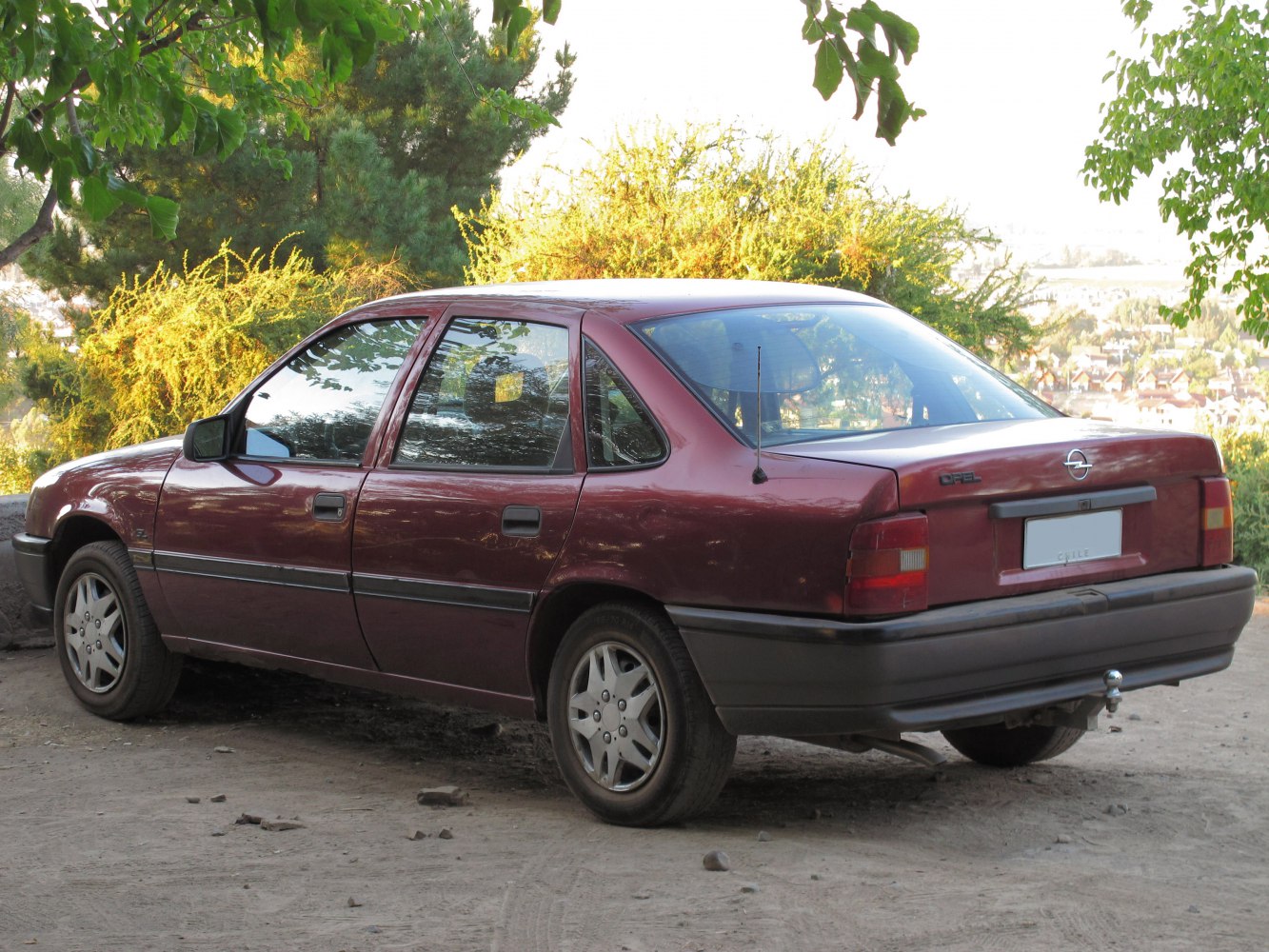 Rear three-quarter view of classic sedan with burgundy paint and black bumpers