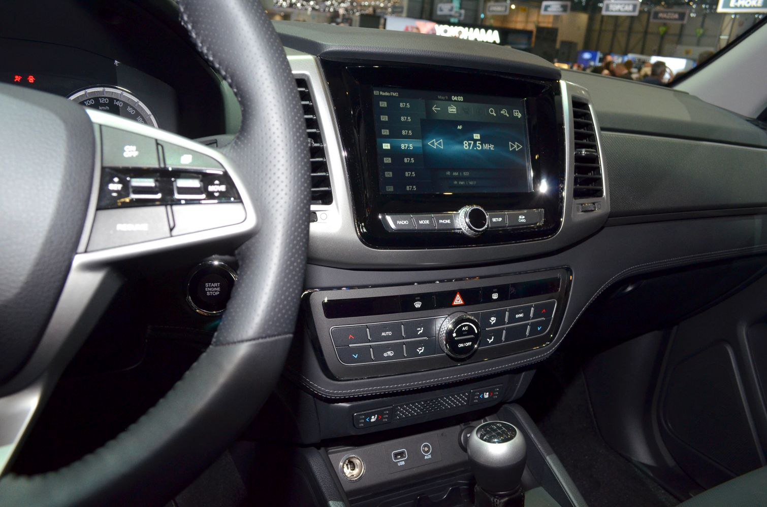 Dashboard with infotainment screen, climate controls, steering wheel, and gear shift