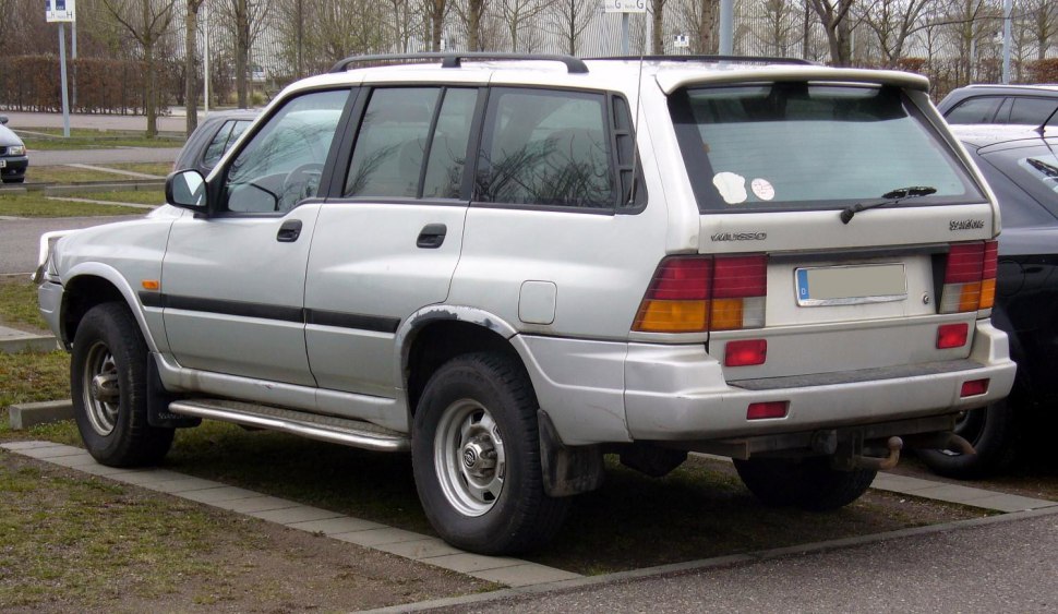 Rear-side view of a silver SUV with distinct taillights and roof rails.