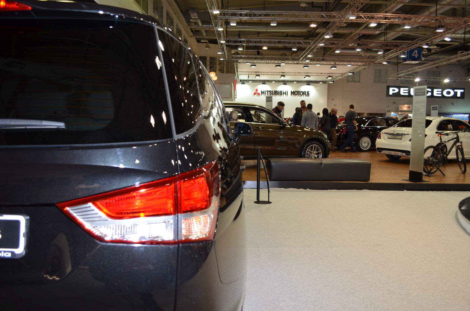 Rear light and quarter panel close-up with reflections of showroom lighting
