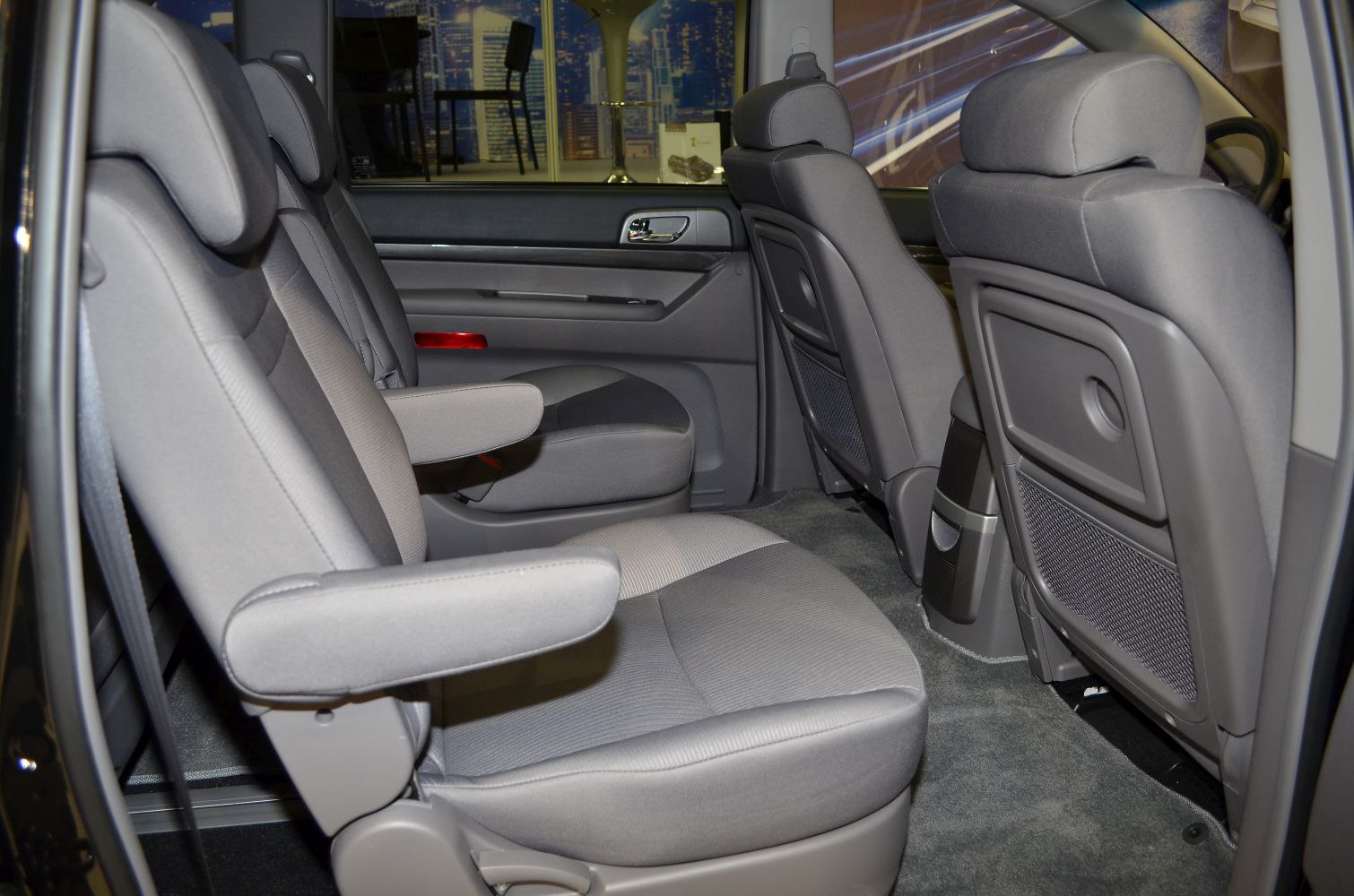 Spacious rear passenger seats with armrests and foldable trays.