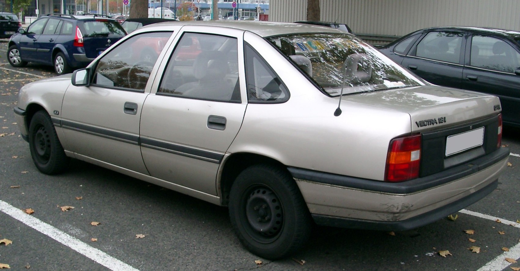 Rear side profile of vintage Opel sedan with distinct 90s styling