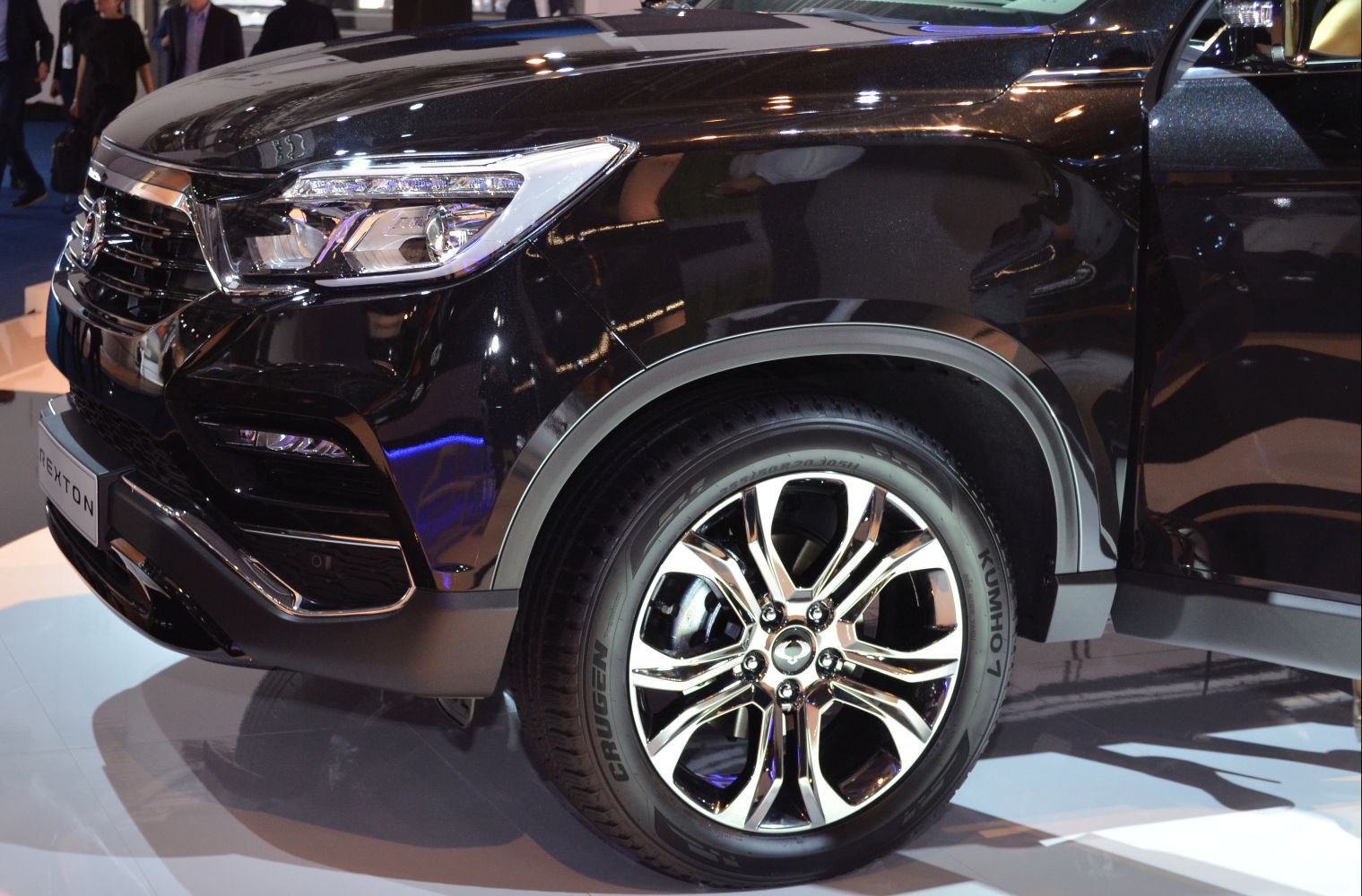 Front headlight and alloy wheel of a black SUV