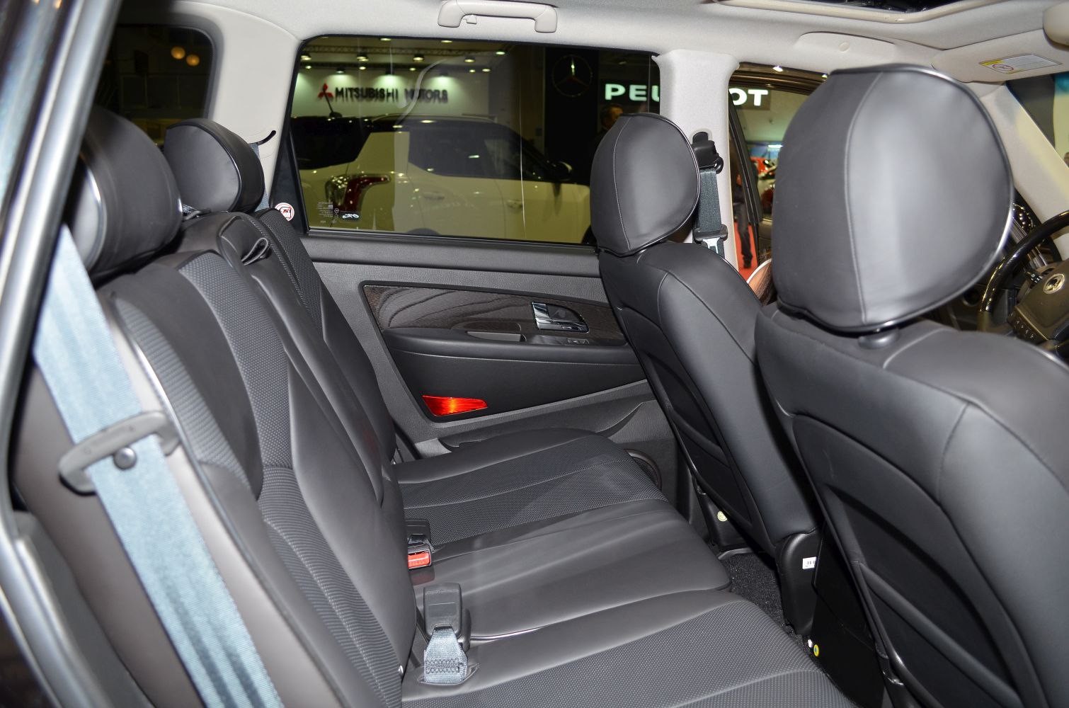 Rear seat area with black leather upholstery and door panel.