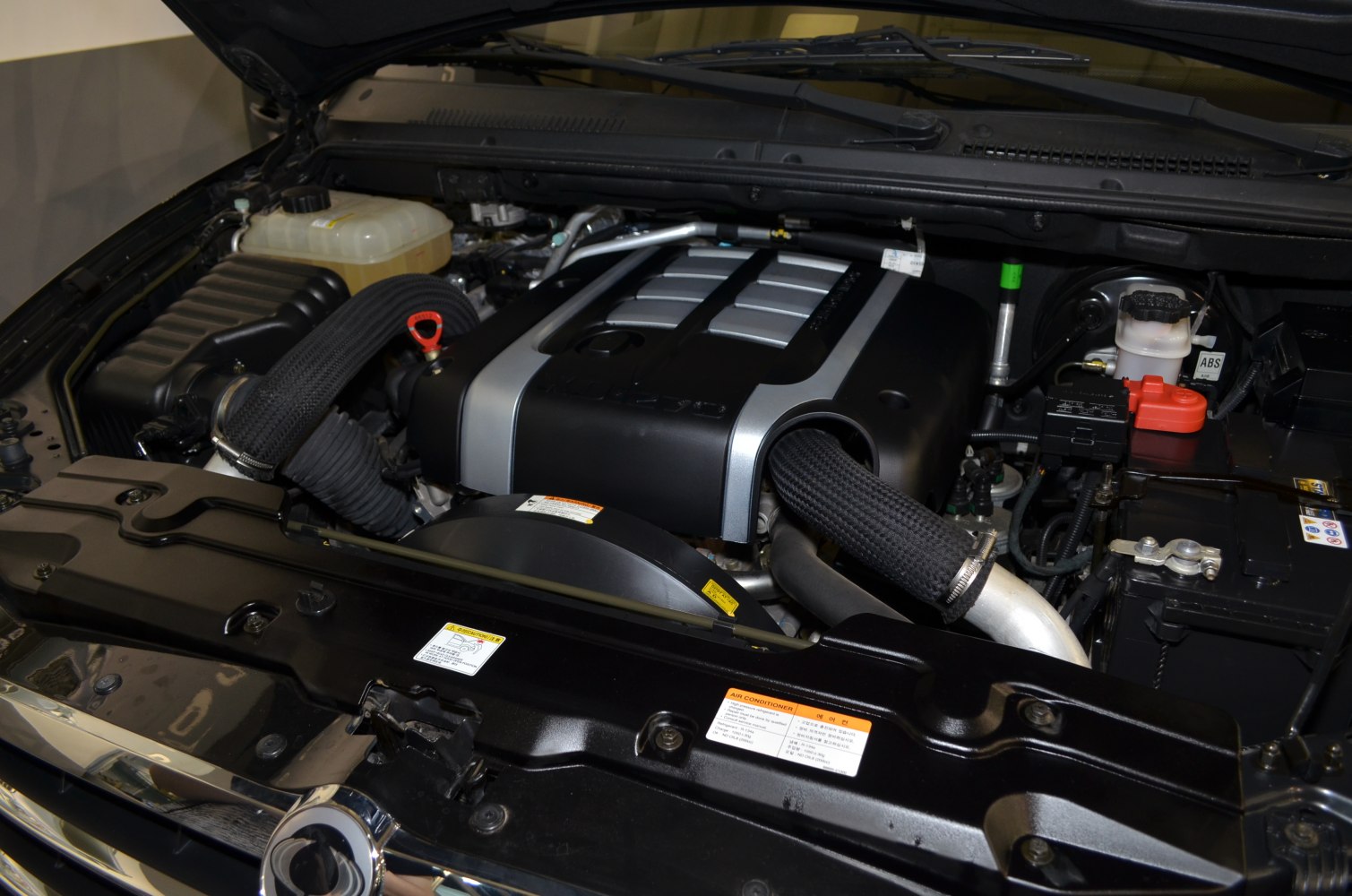 Engine bay with covered engine and fluid reservoirs