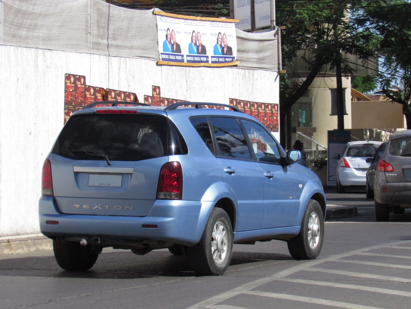 Blue SUV rear view with vertical tail lights and roof rails