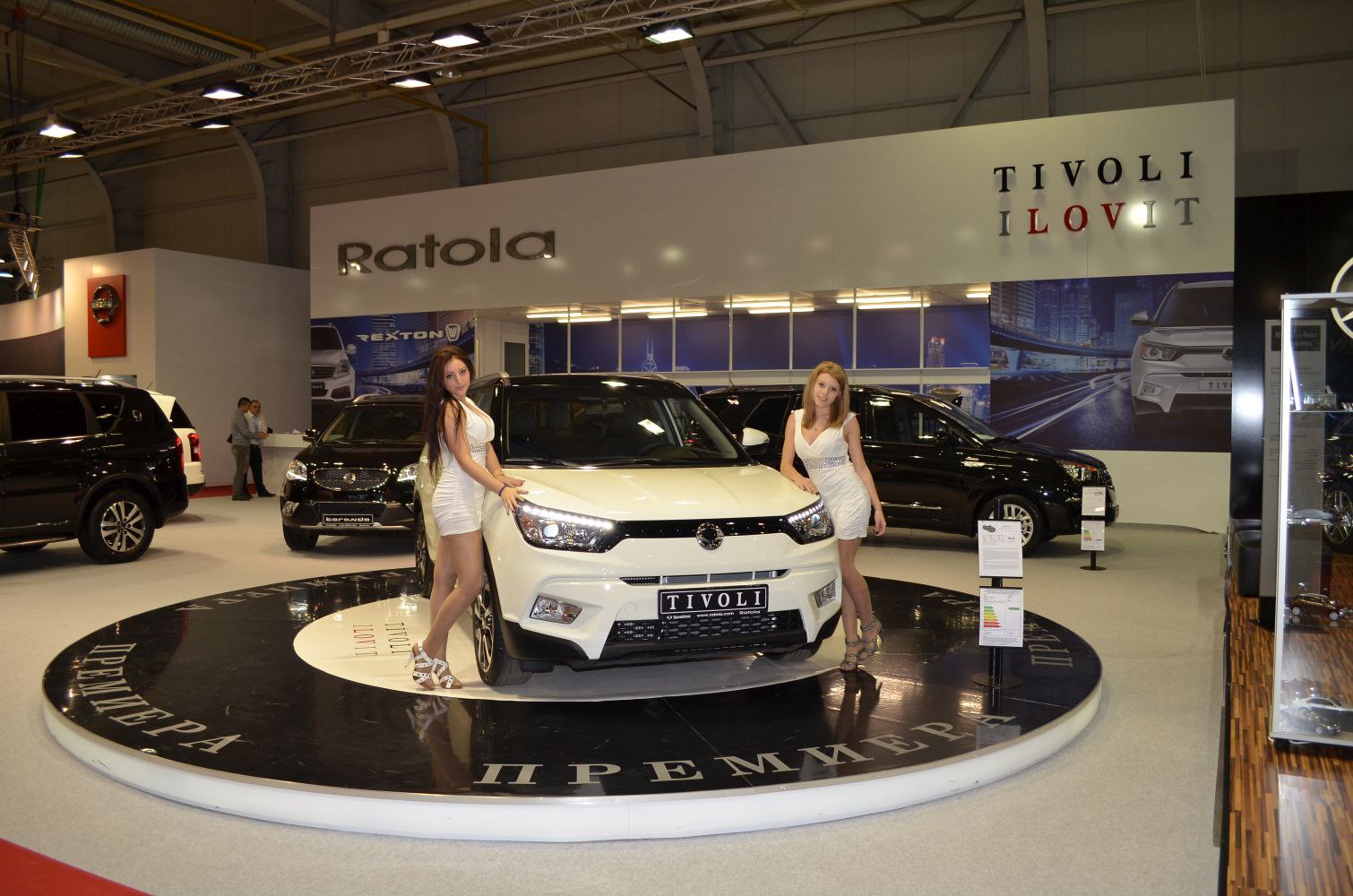 White compact SUV front view with LED headlights on rotating platform.
