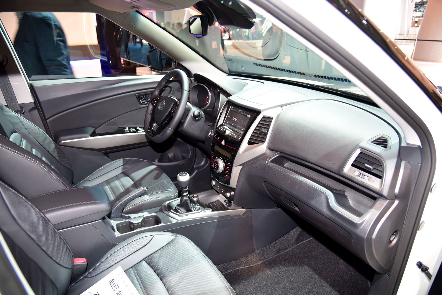 Interior cabin with manual gear shift, dashboard, seats, and center console.