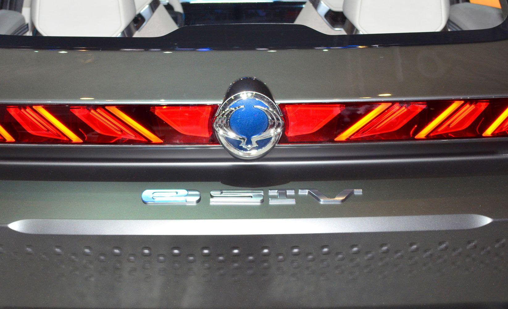 Close-up of red LED tail lights and rear emblem on vehicle back