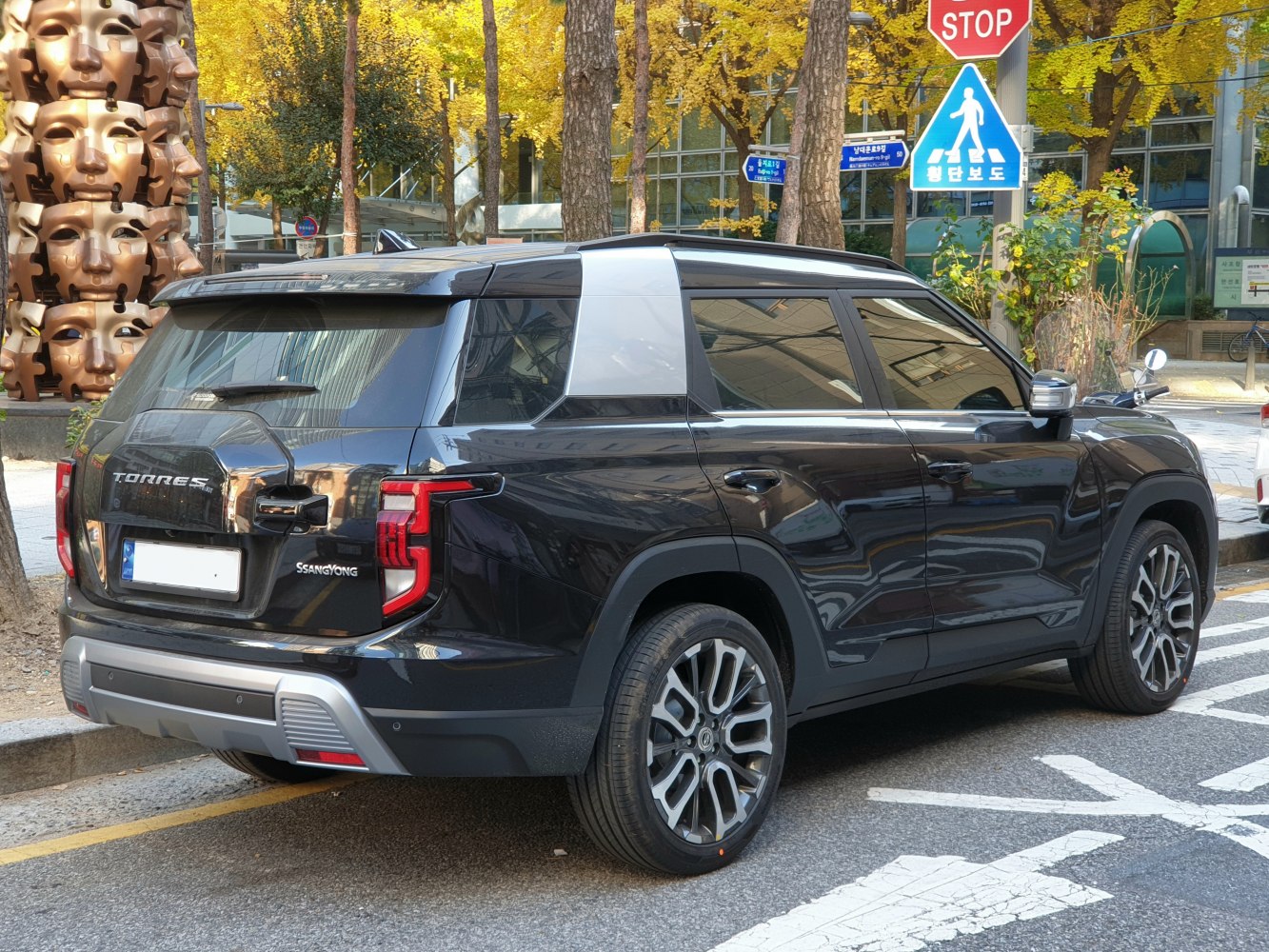 Rear and side profile of a sleek SUV with distinctive rear lights and large alloy wheels.