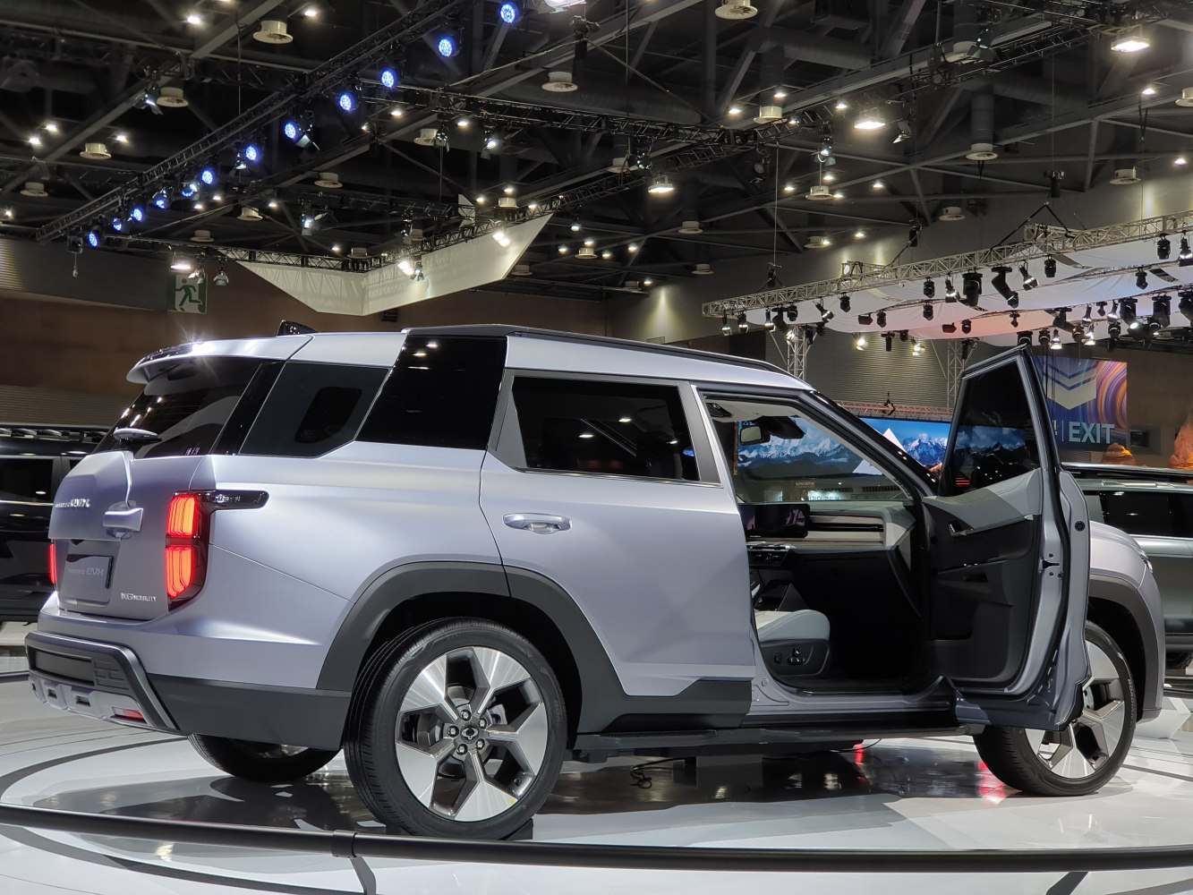 Rear and side profile with open front door of a modern SUV