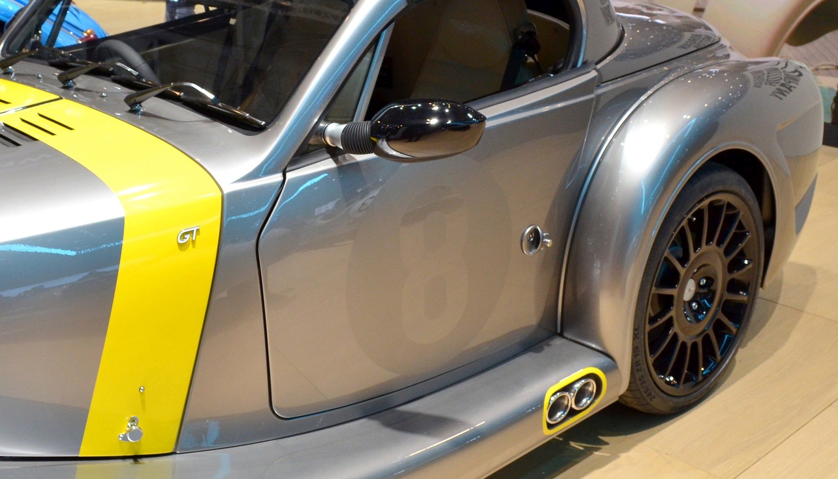 Close-up of side mirror, rear fender, and dual exhaust pipes