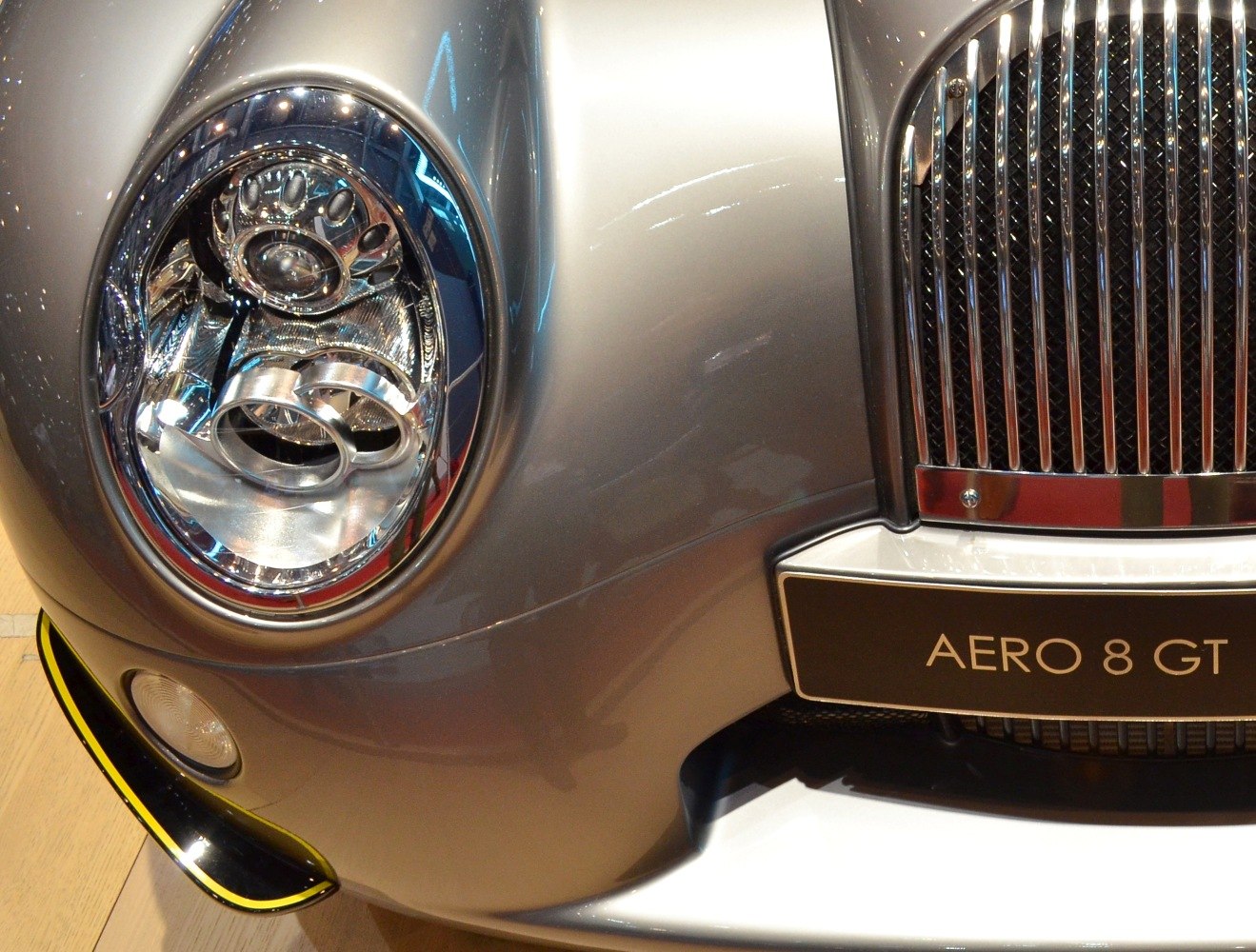 Close-up of front headlight and chrome grille with badge