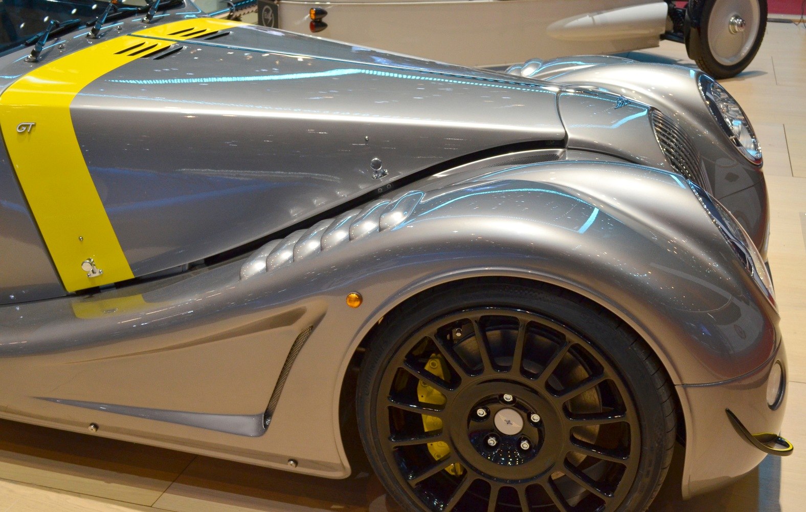 Aerodynamic front fender with vents and black multi-spoke wheel.