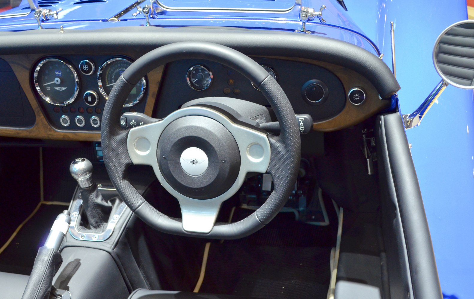 Steering wheel and classic dashboard with gauges and manual gear shifter