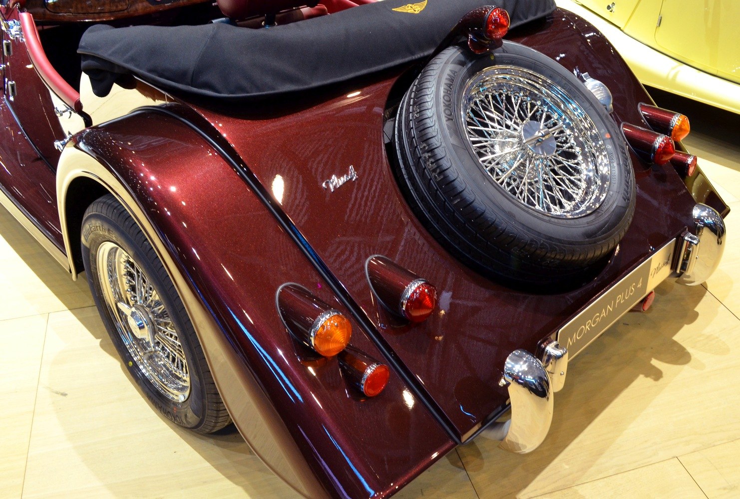 Rear view with curved fenders, spare wire wheel, and classic lights
