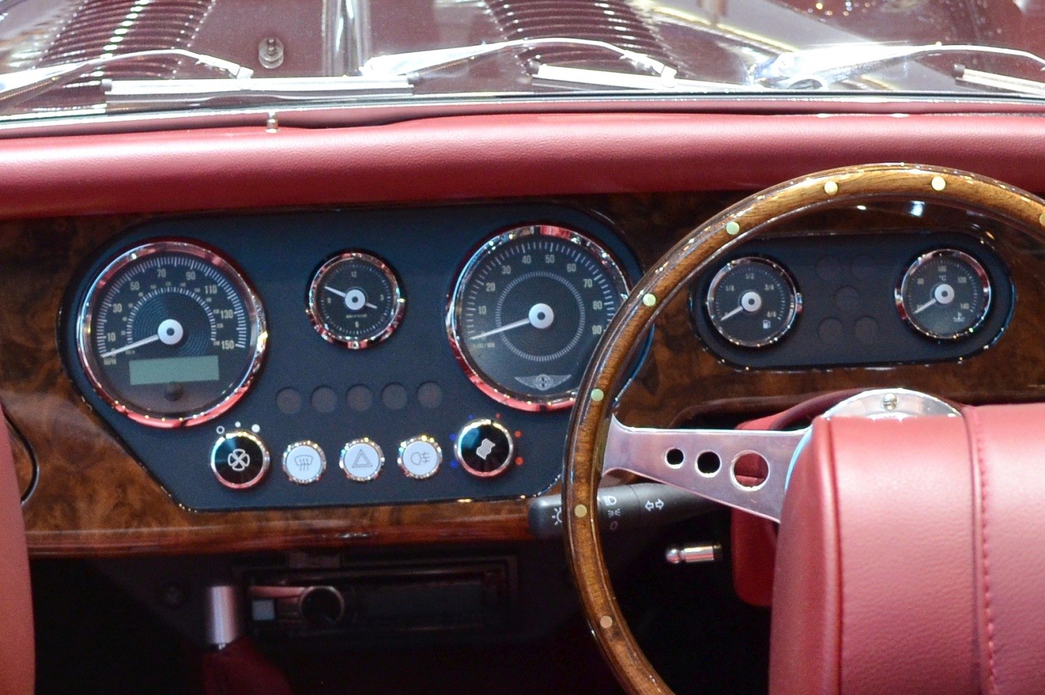 Wooden dashboard with analog gauges and vintage-style steering wheel