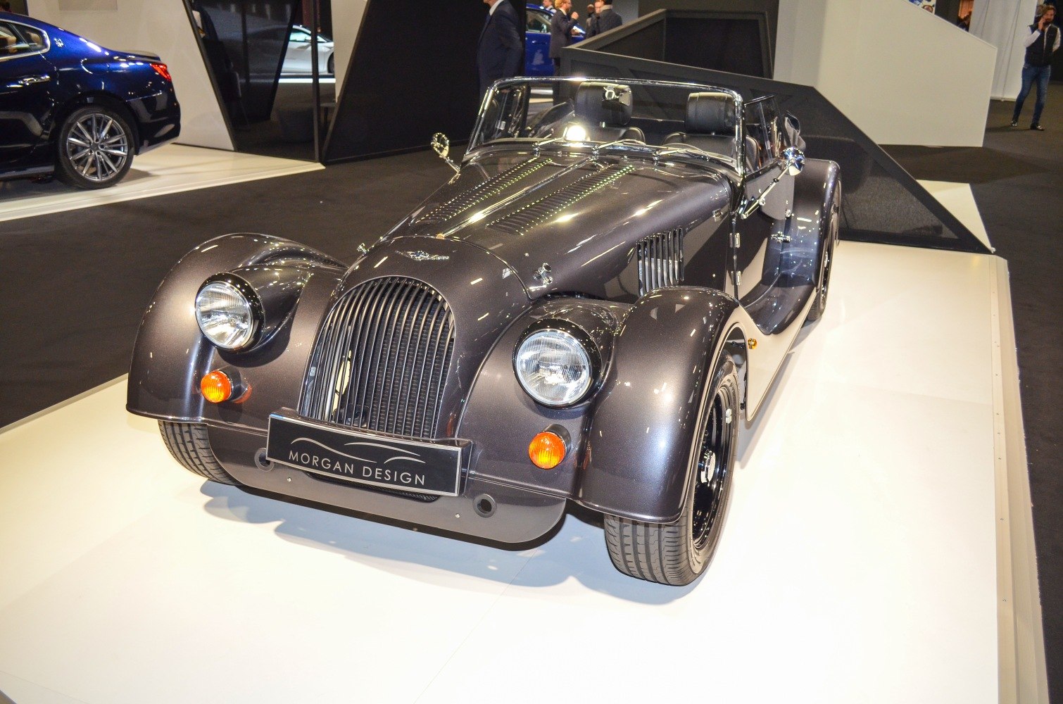 Classic roadster front with round headlights and curved fenders.