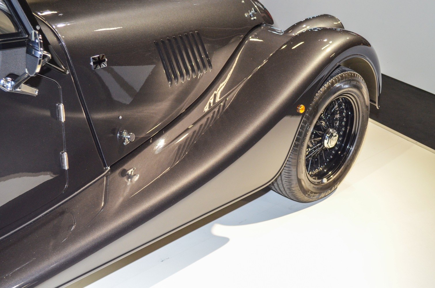 Classic front fender and wire-spoke wheel of a vintage style car
