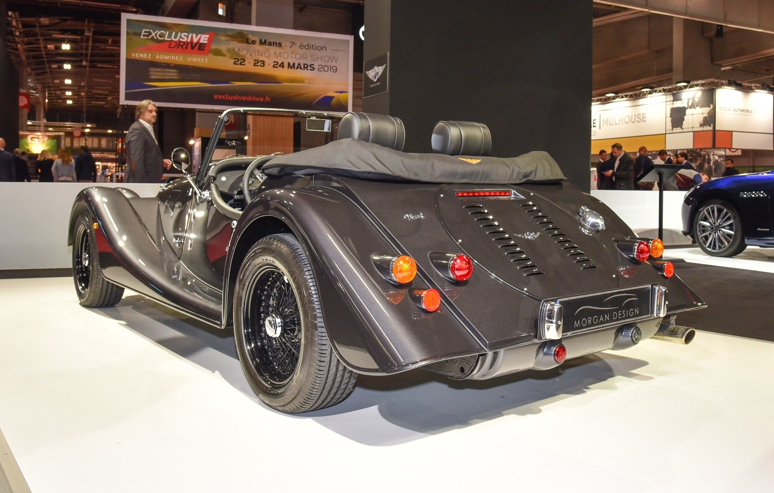 Vintage-style open-top roadster rear with wire wheels and taillights